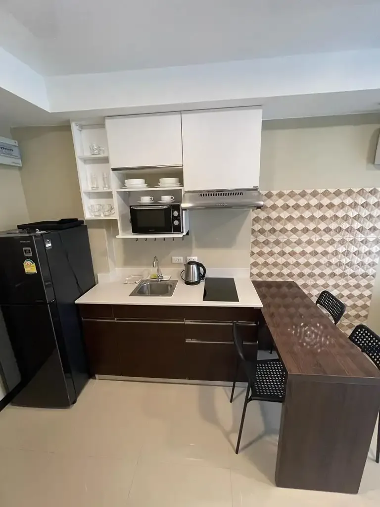 Кухня с холодильником, плитой и шкафами в квартире MBC Condotel, Май-Кхао, Пхукет