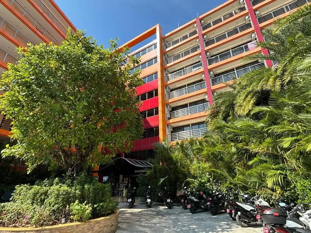 Въезд и парковка у корпуса MBC Condotel с красными акцентами фасада, Май-Кхао, Пхукет