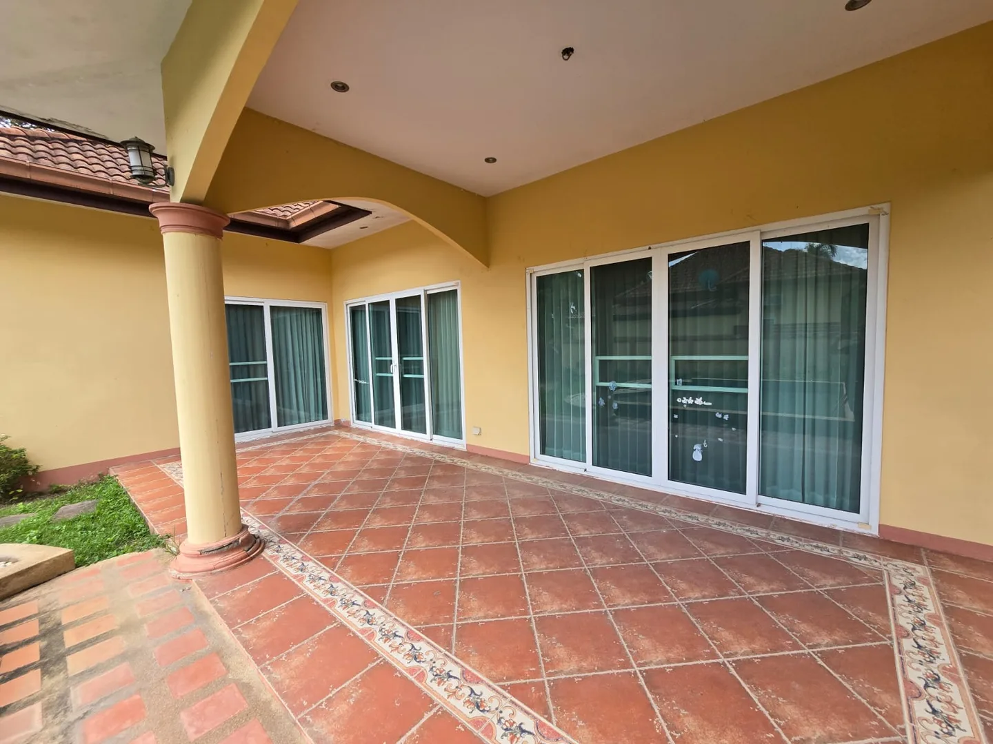 Крытая терраса с колоннами, терракотовой плиткой и раздвижными окнами в Single House Huay Yai, Паттайя
