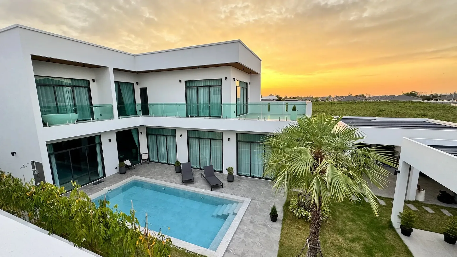 Вид с высоты на виллы и бассейны The Sugar Palm Villas на закате, На-Джомтьен, Паттайя