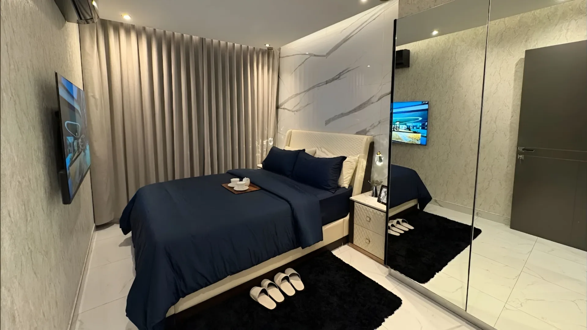 Спальня с тёмно-синим текстилем и мраморной стеной в отделке ЖК Zenith Pattaya